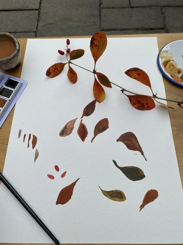 red leaf frond with painted leaf motifs on watercolour paper