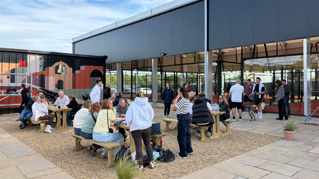 Photo of several people in a courtyard area at Rally Yard padel club