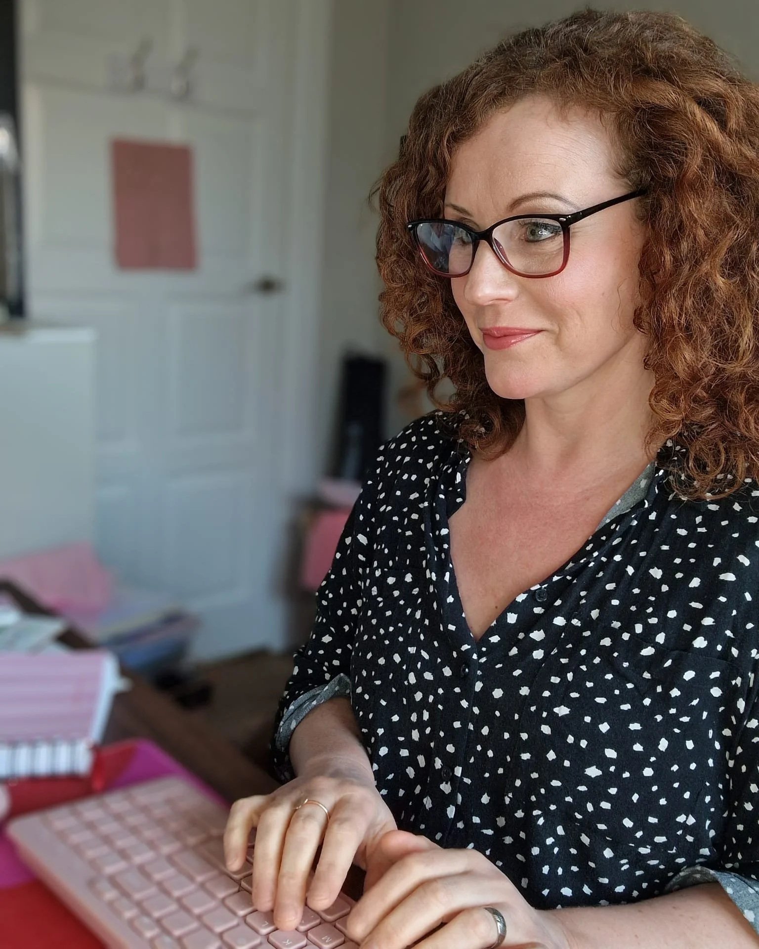 “Joanne Pearce working at her desk, writing newsletters and marketing content for small businesses.”