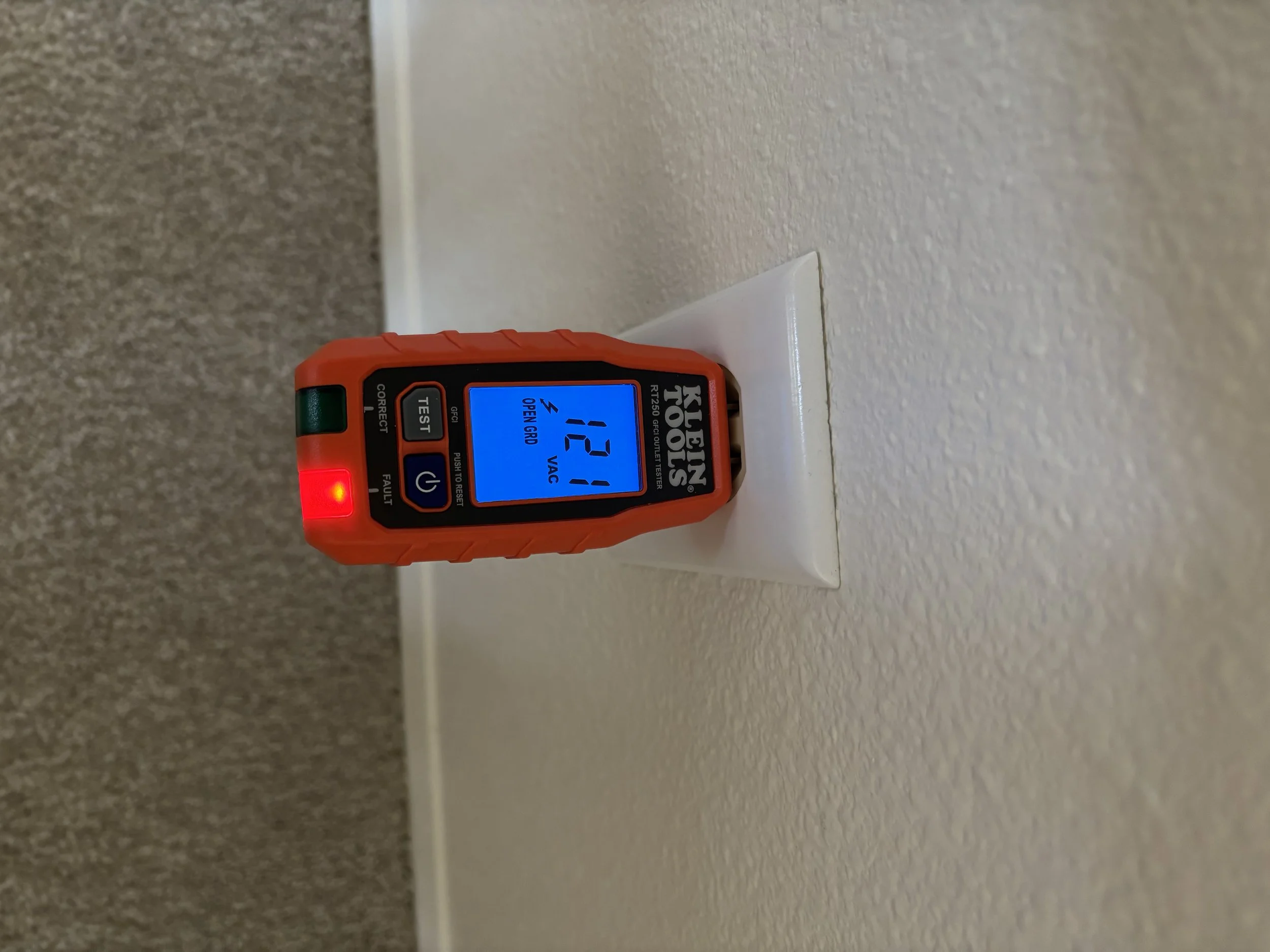 A laser measuring device placed against a wall with a digital display showing a measurement of 121 centimeters.