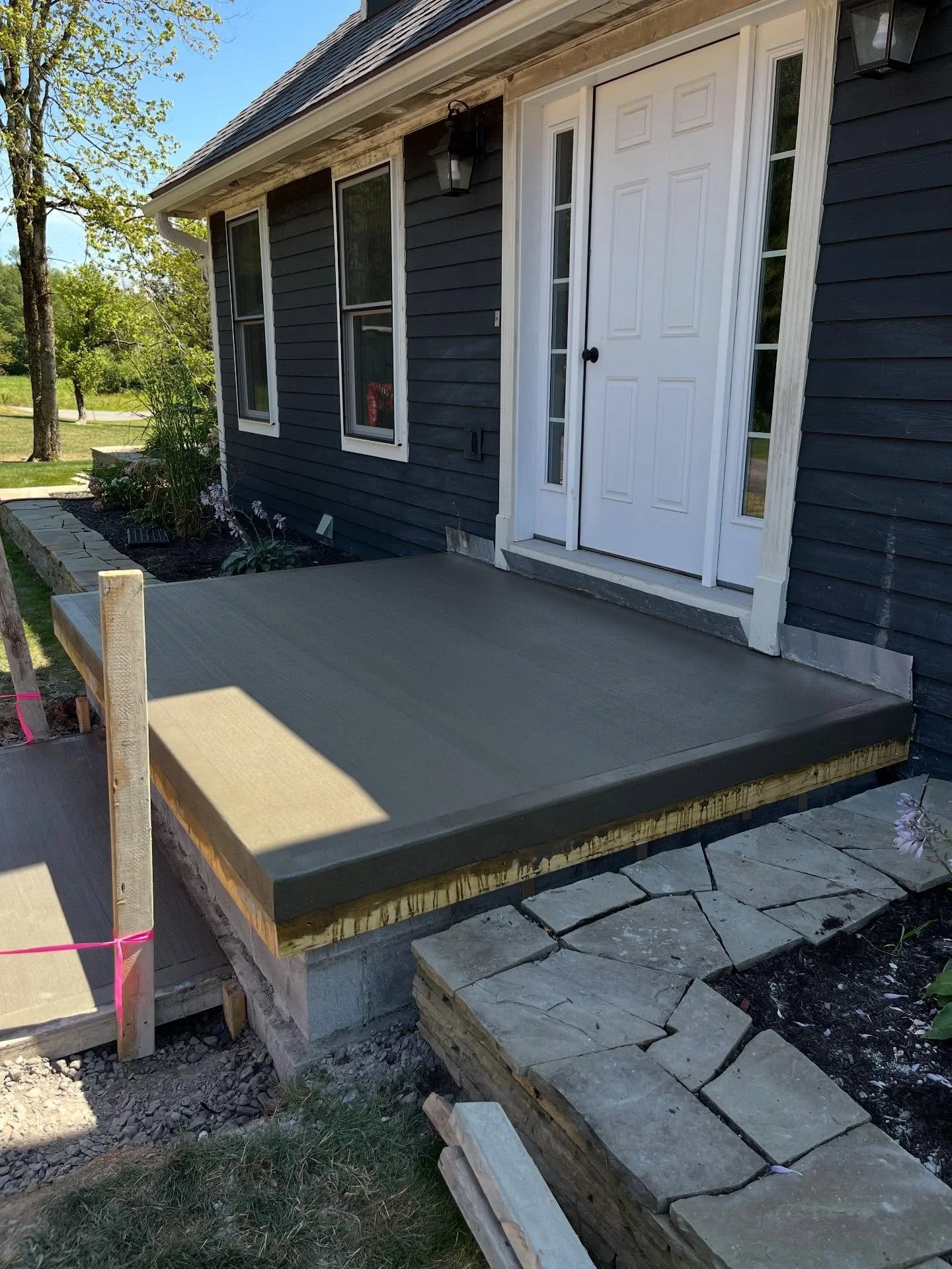Part two of this three-phase porch project. After backfilling the block foundation, we formed the porch cap and connecting sidewalk with steel mesh reinforcement. Mid-pour, we removed the porch forms to create a smooth, sponge-finished exposed edge. 