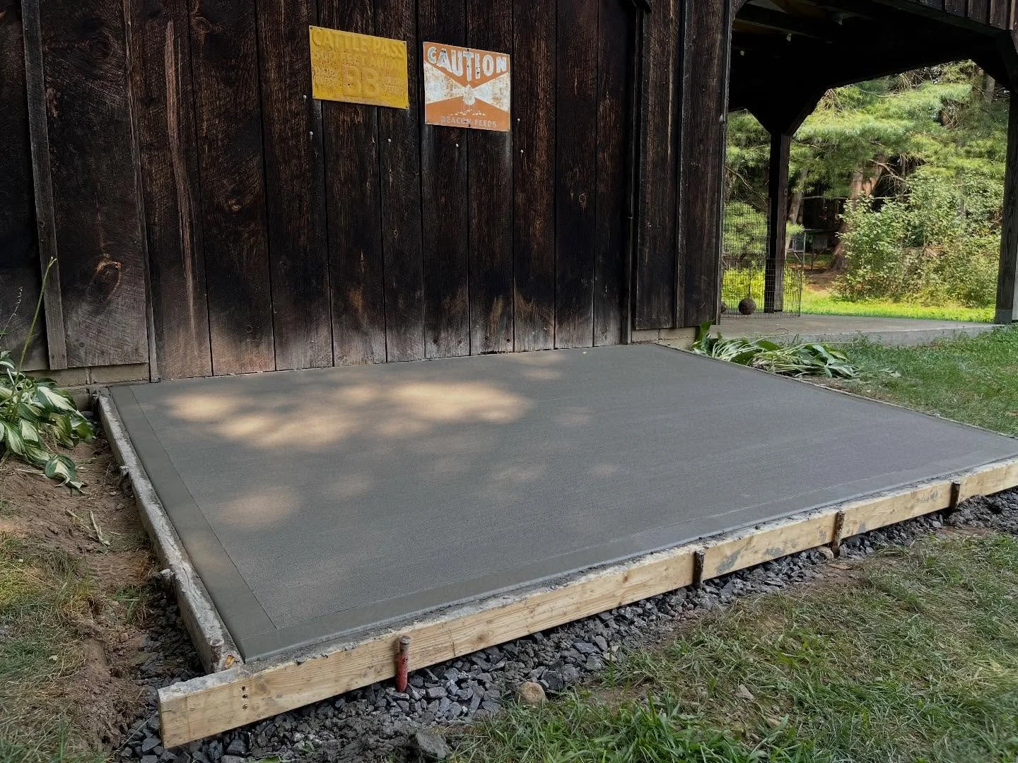 Getting mowers, tractors, and other equipment in and out of an older shed or barn can be a challenge. To make life easier for this homeowner, we excavated the area, installed and compacted a crusher-run base, pinned the new slab to the existing barn 