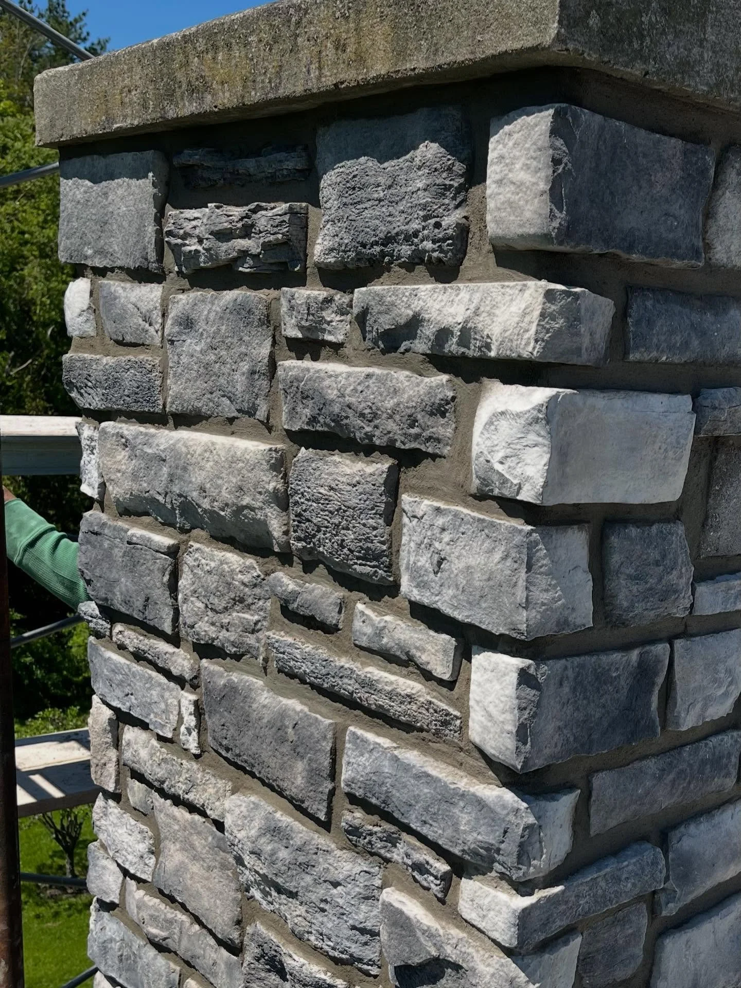 Chimneys endure some of the harshest weather conditions on a home. On this project, stones were falling from the chimney, creating a safety hazard for the homeowner. We set up scaffolding, removed all loose stone, applied a new mortar scratch coat, m