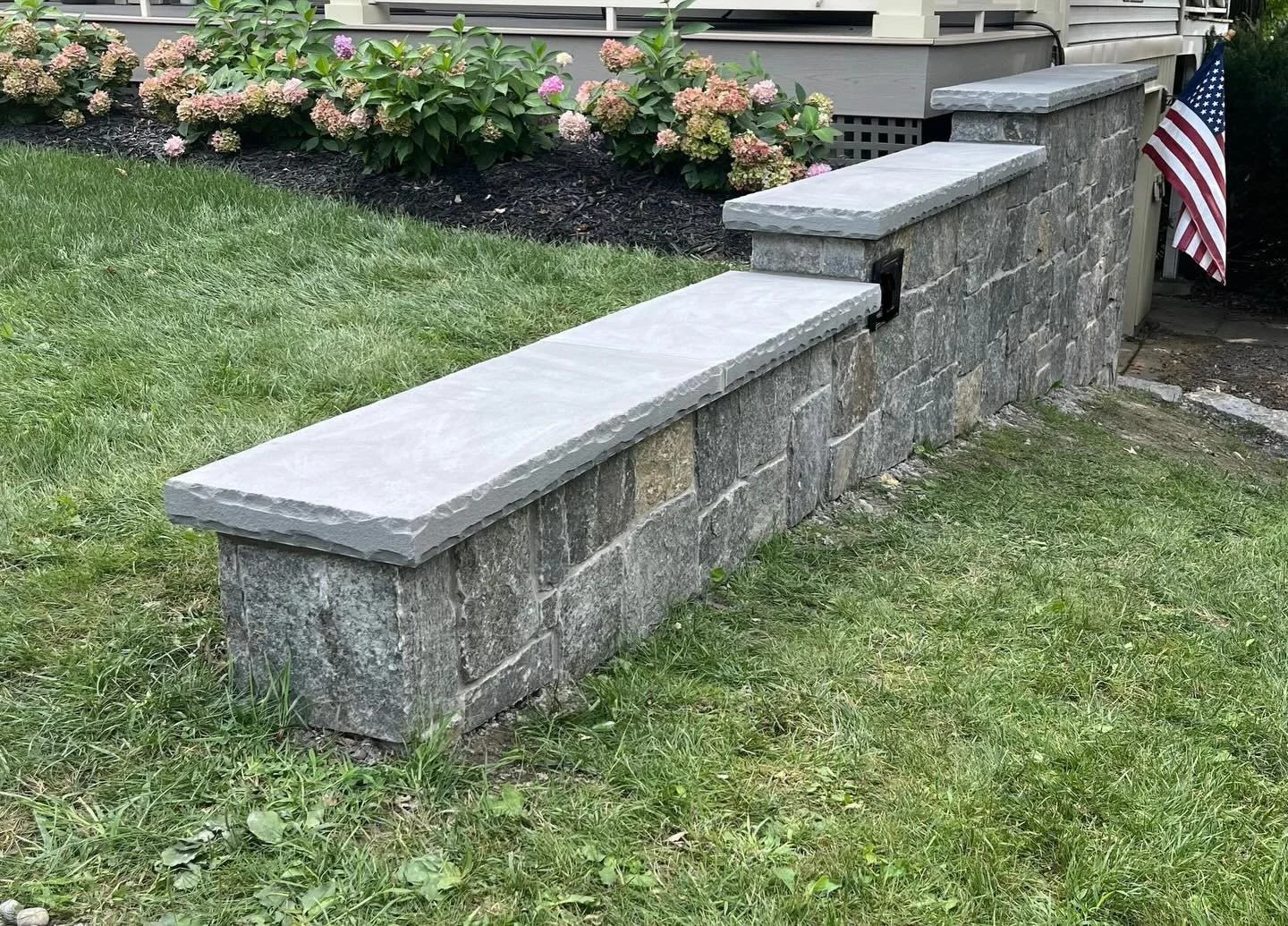 Part two of the retaining wall project included installing @adirondacknaturalstone veneer and finishing the wall with a custom 3-inch bluestone cap. We began by applying a mortar scratch coat across the entire surface for maximum bond strength, then 