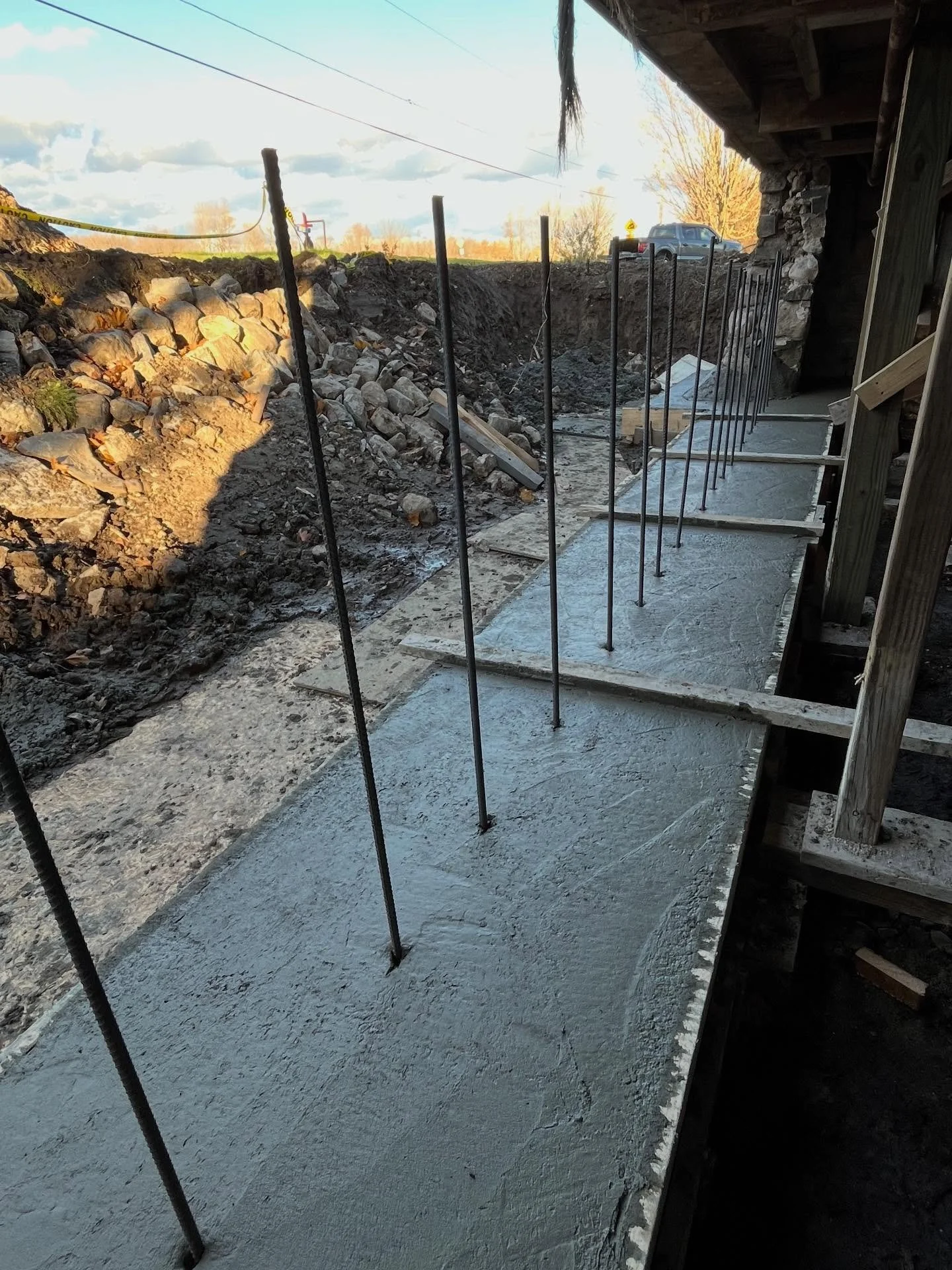 Part one of a three-phase foundation restoration and repair project. We began by bracing the structure and excavating the deteriorated stone wall. From there, we formed and poured a double-width footer that wrapped around the remaining wall corners a