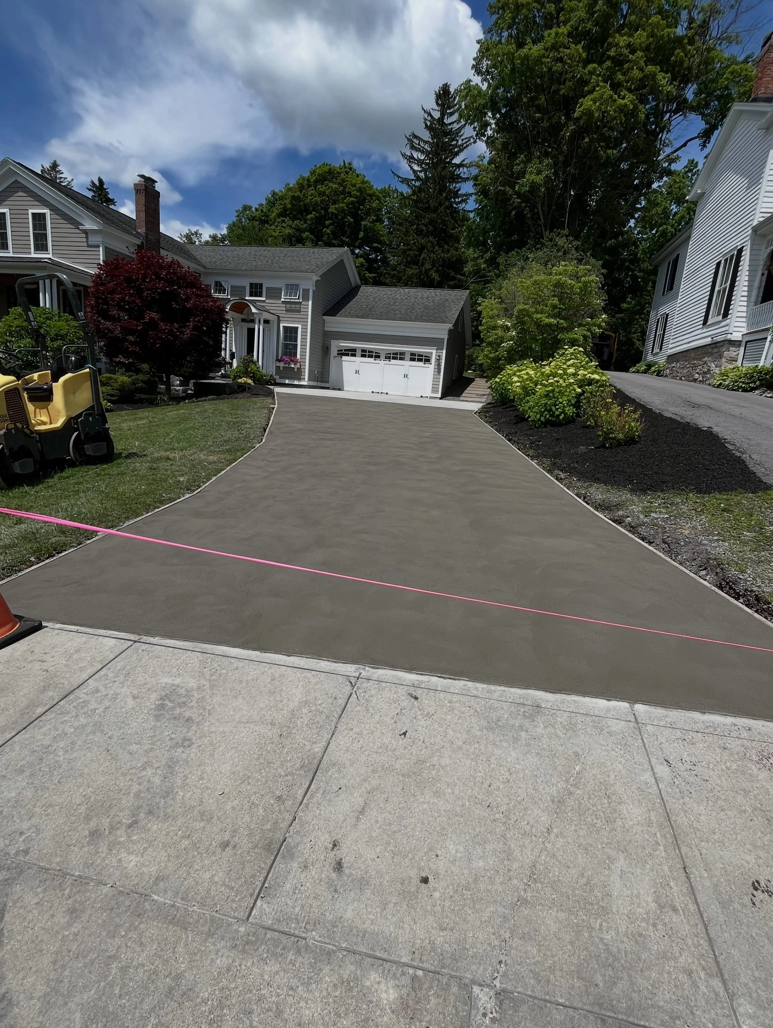 Concrete driveways can significantly enhance the curb appeal of any home. We began by excavating the existing gravel driveway and installing a compacted crusher-run base. The area was then formed and reinforced with heavy-duty 6-gauge steel mesh for 