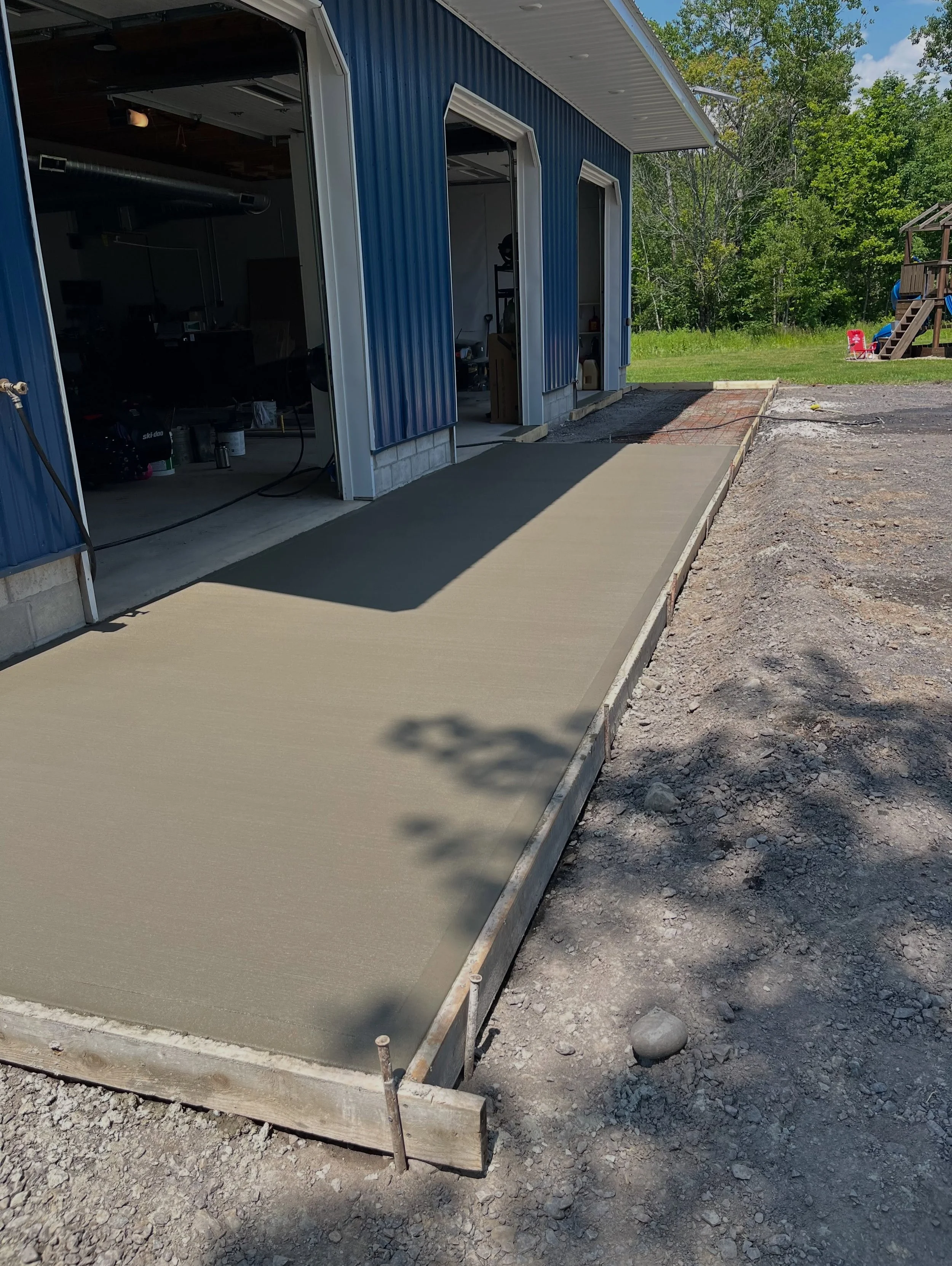 This homeowner wanted to add a concrete apron in front of their garage that extended to two entryway doors. During the same pour, we also repaired several areas of the existing concrete floor that had begun to deteriorate. After excavation, we formed