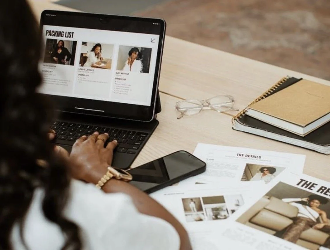 Web designer at Clear Canvas Design reviewing client website mockup on tablet with project notes and phone on desk