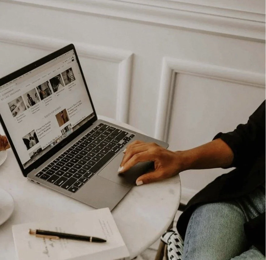 Small business owner browsing a custom editorial style website designed by Clear Canvas Design on a laptop