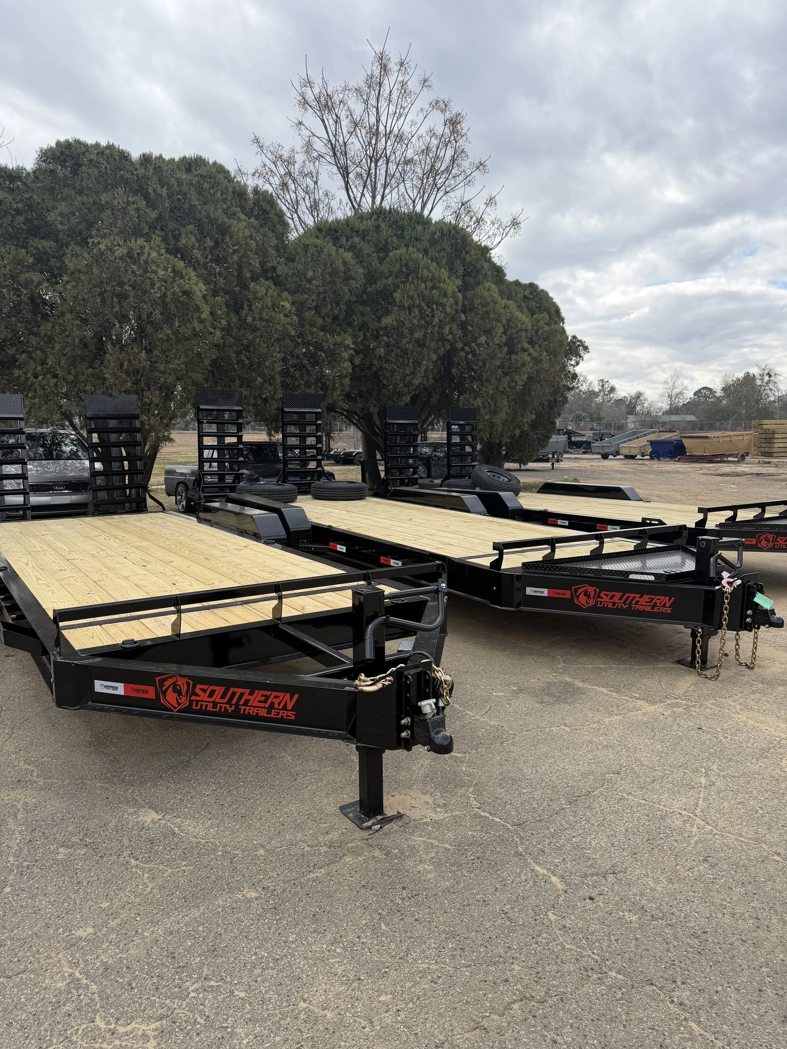 Three different sized equipment trailers lined up, showing size and capacity differences