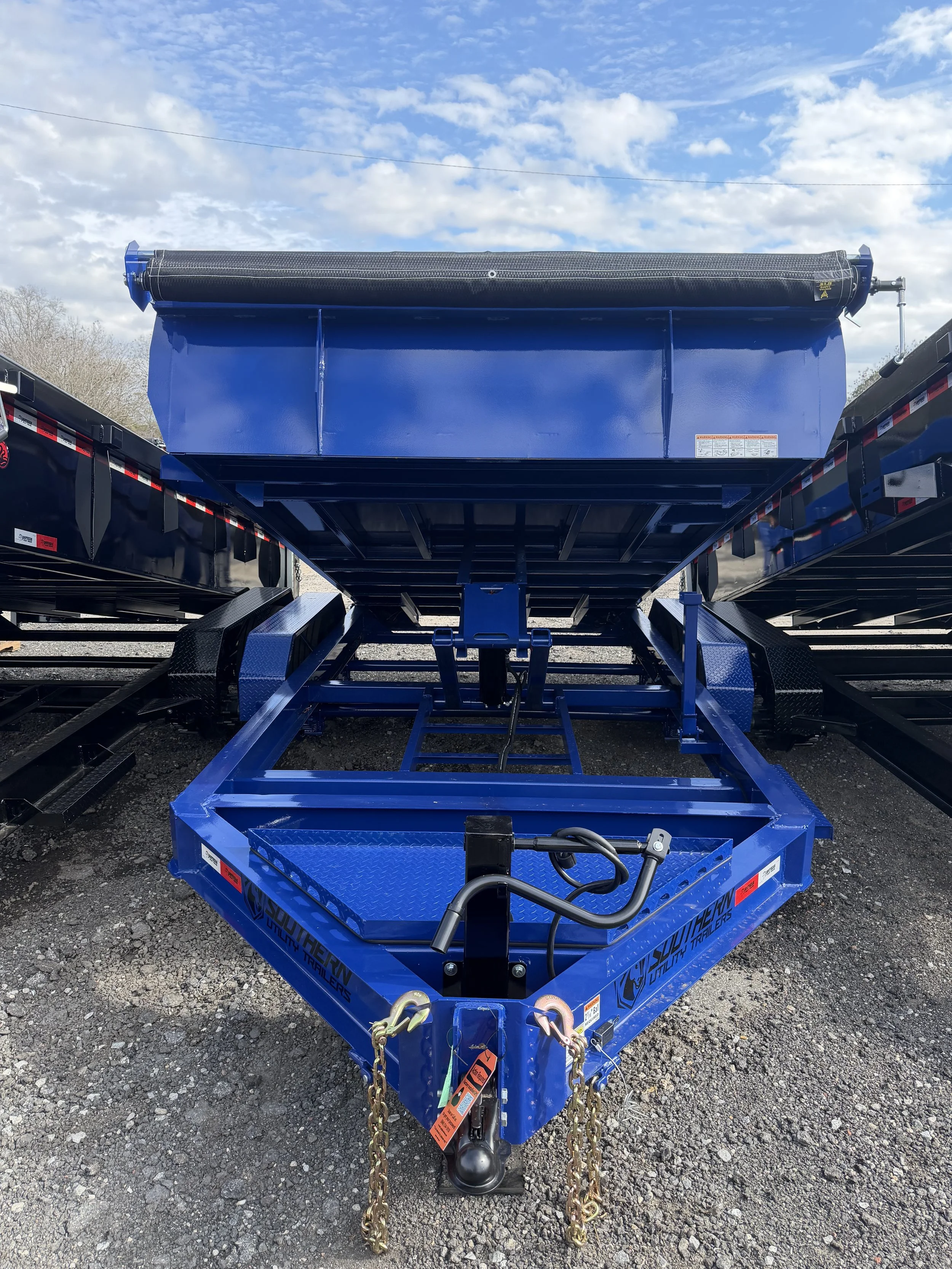 Blue dump trailer with heavy-duty scissor hoist lifting the bed
