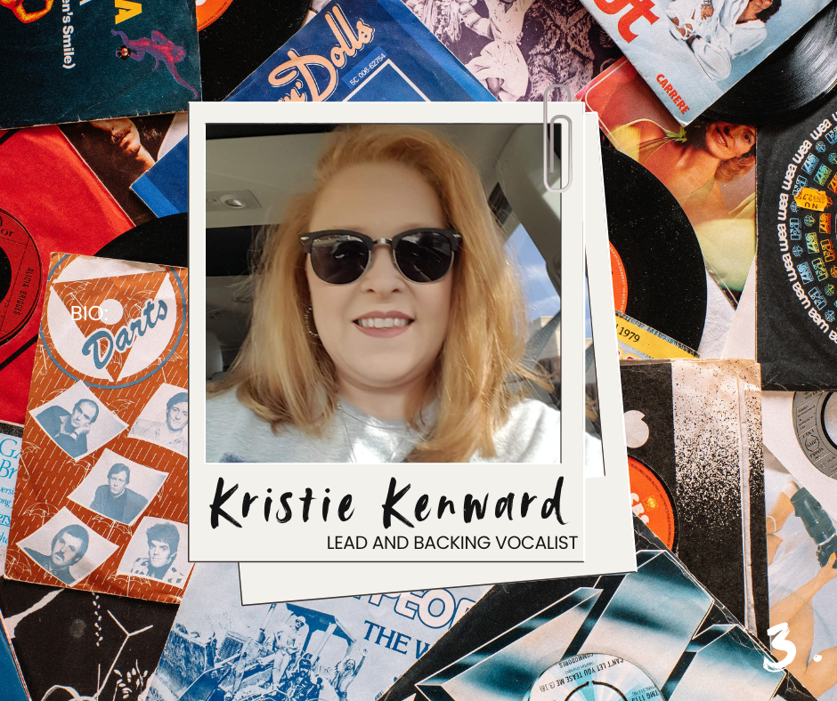 A woman with shoulder-length red hair wearing dark sunglasses and a gray shirt, smiling while sitting in a car, with a background featuring a collage of vinyl records and album covers.