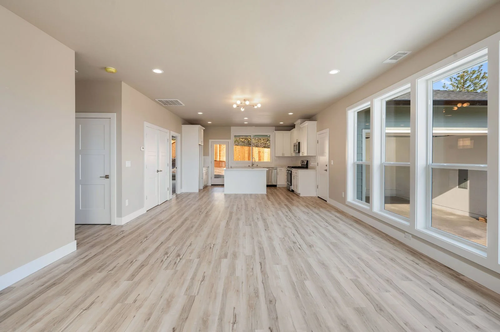 Professional real estate photography and drone imagery- Straight on of kitchen and living room space. 