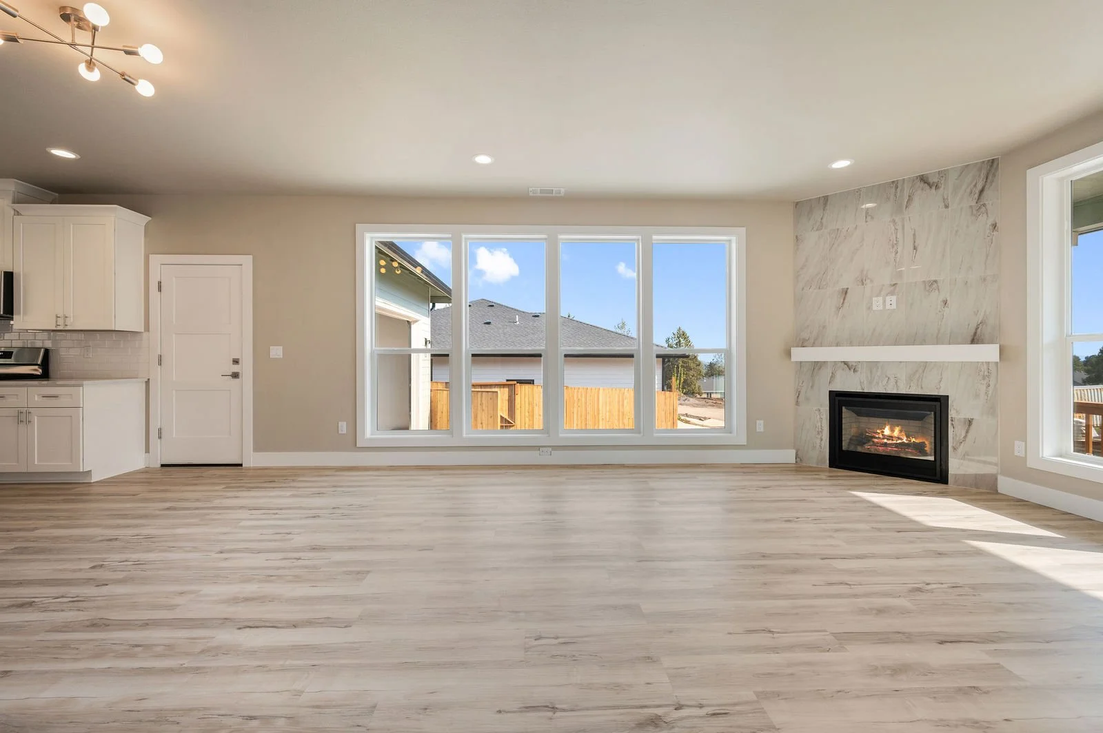 Professional real estate photography and drone imagery- Interior shot of living room and partial of kitchen. 