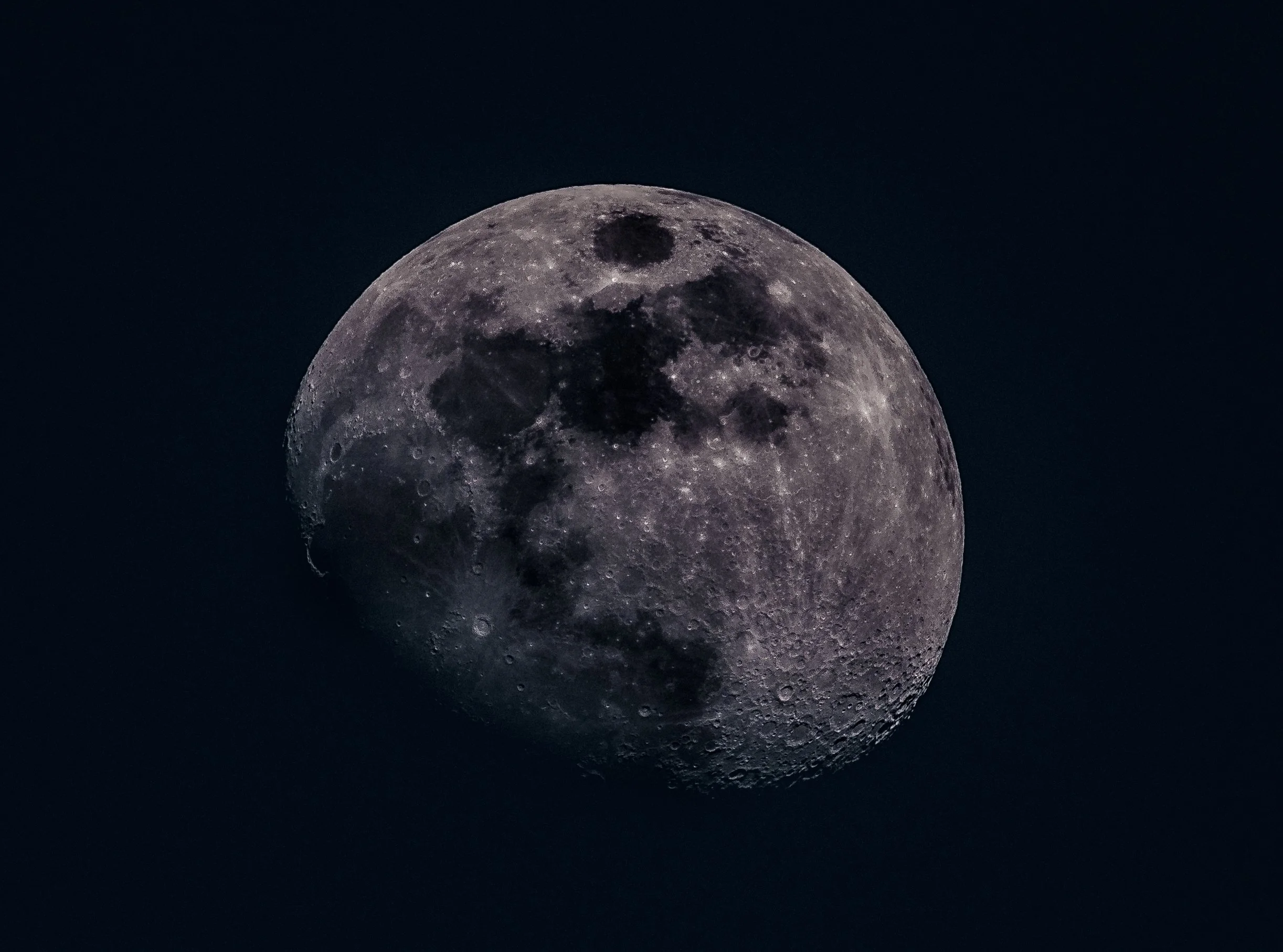 Close-up of the moon showing craters and dark lunar maria against a dark sky.
