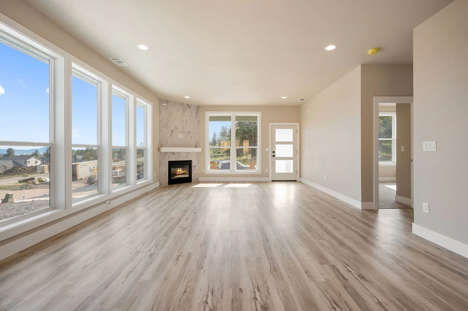 Professional real estate photography and drone imagery- Interior shot of living room with fireplace and large windows. 