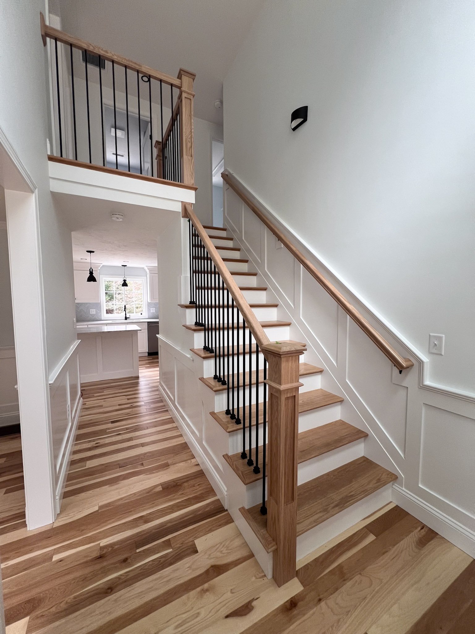 Interior staircase with wood treads and black balusters installed in Massachusetts