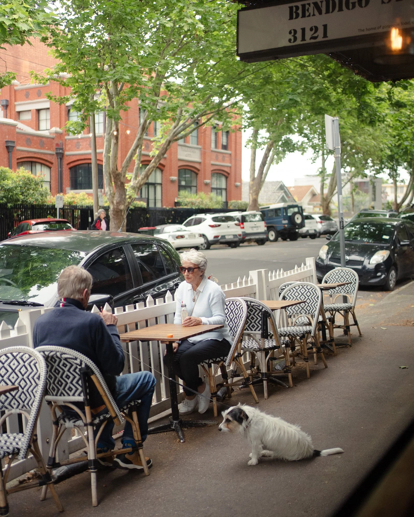 Dog-friendly outdoor seating at Bendigo St Milk Bar cafe in Richmond, with locals enjoying coffee along a leafy neighbourhood street.