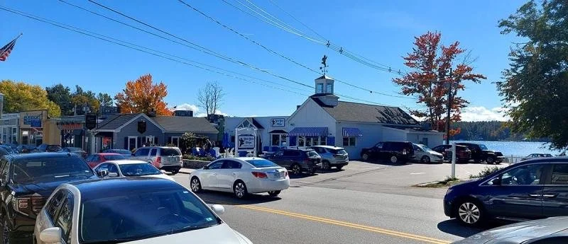 Cars, lakes, and small buildings along the main street of Wolfeboro.