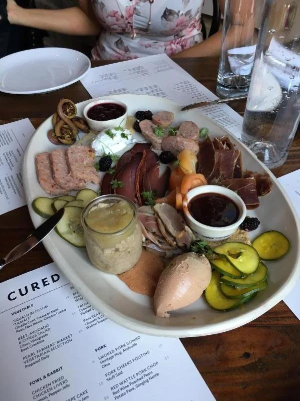 A charcuterie board with a variety of veggies, dips and  meats from Cured in San Antonio.
