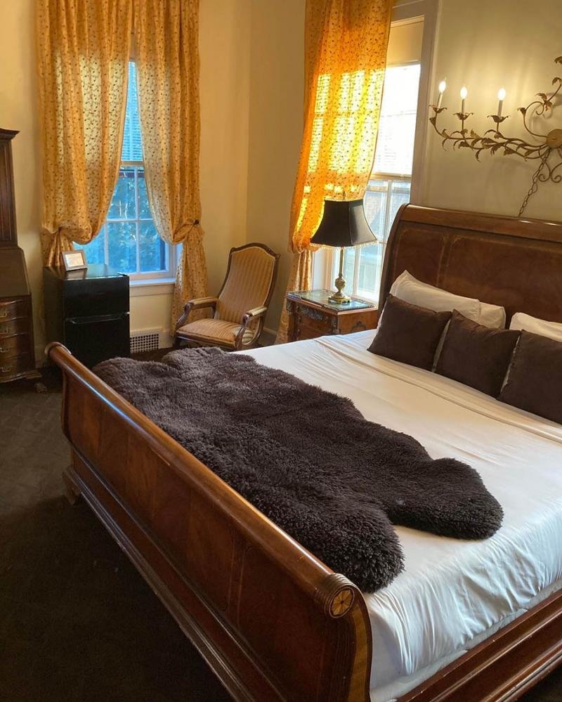 A bedroom with yellow curtains and a big bed where Ulysses S. Grant once slept.