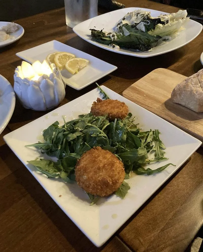 Dishes from Sopra in Lake Geneva sit on a wooden table.