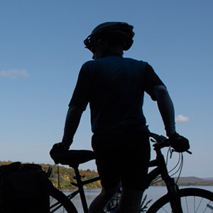 Silhouette of a person with a bicycle outdoors on a clear day