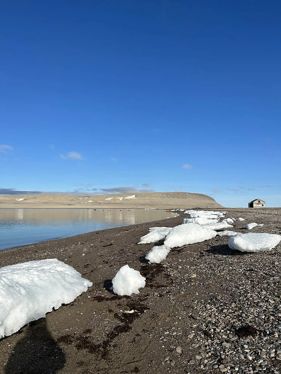 Desert mountains reflect in the waters of the High Arctic.