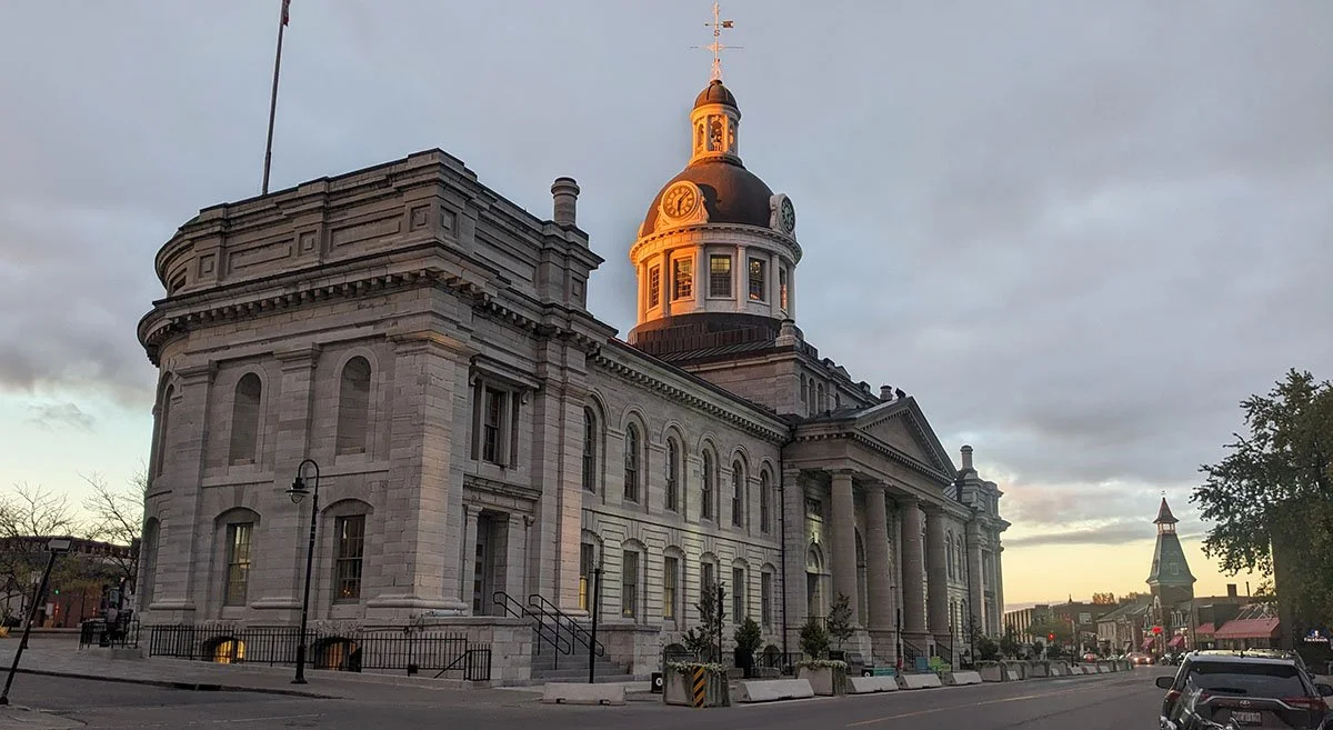 The clocktower of Kingston City Hall glimmers in the sunset of golden hour.
