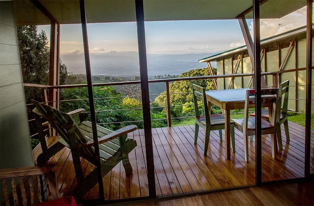 A table on a balcony overlooking jungle and mountain valleys in Costa Rica from Chayote Lodge Cabin.