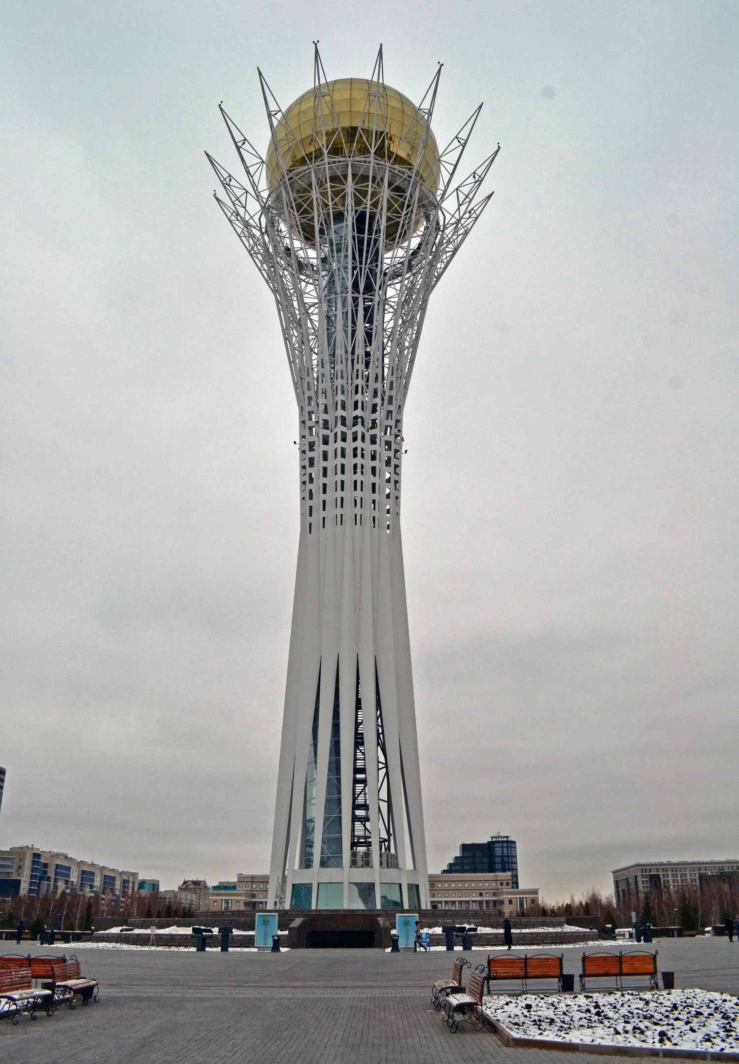 The tall spires at the top of the Bayterek Tower on a gray day.