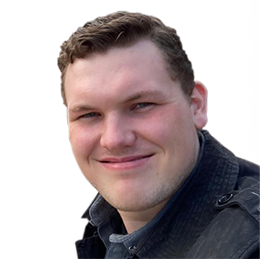 A smiling man with short brown hair, wearing a dark jacket, against a plain white background.