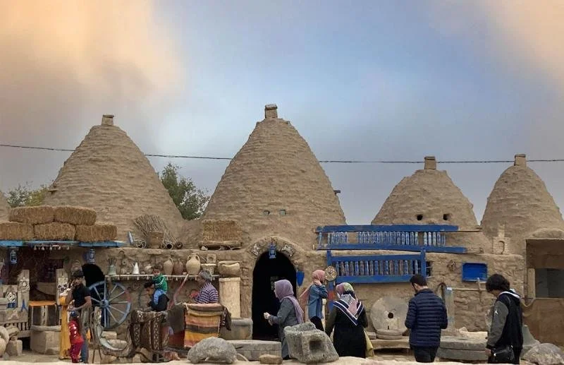 Brown, beehive shaped homes in Harran tower above marketplaces in the street.