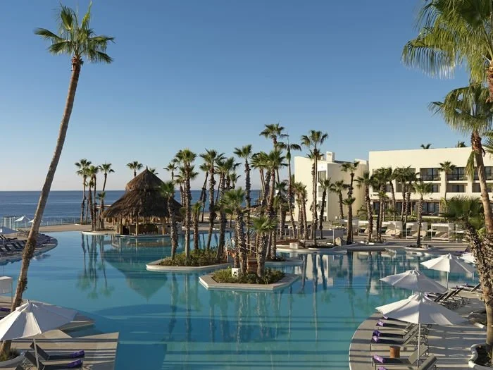 Palm trees reflect in the pool over Paradisus Resorts in Cabo San Lucas.
