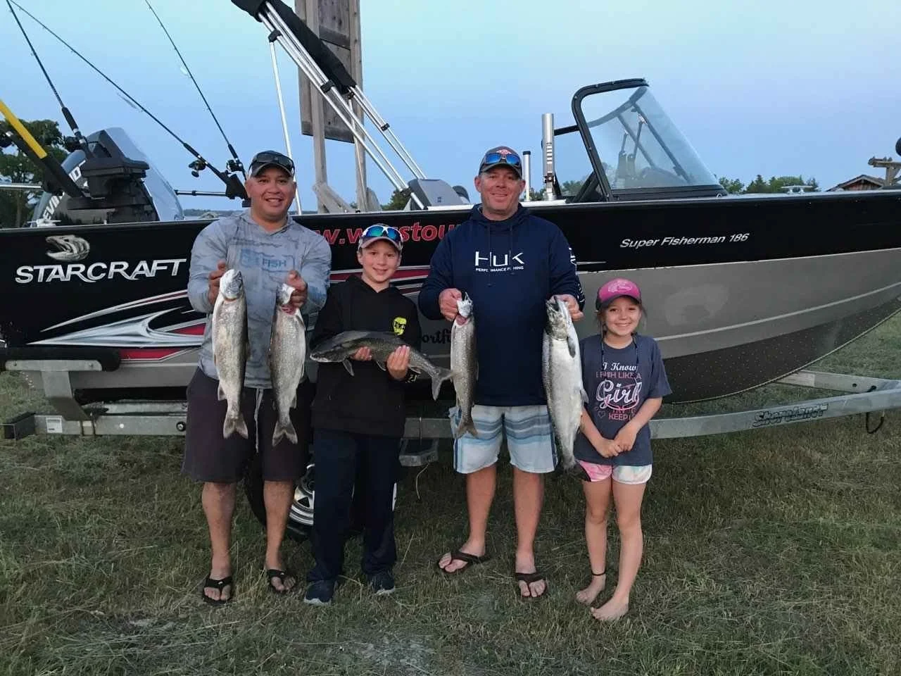 A grou of visits showing salmon caught from fishing with Wasse Giizhik Tours.