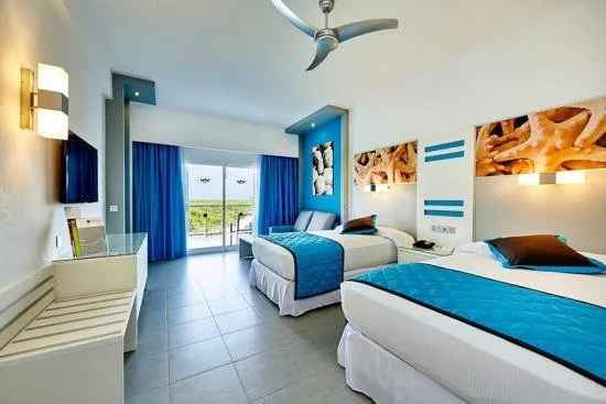 White and blue bedsheets at Hotel RIU Dunamar overlooking the ocean in Quintana Roo.