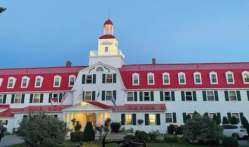 The red and white facade of the Hotel Tadoussac overlooking the bay in Fjord du Saguenay.