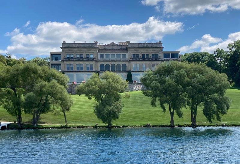 Lake Geneva's largest mansion, the Stone Manor, sits high above a stream and green grass.
