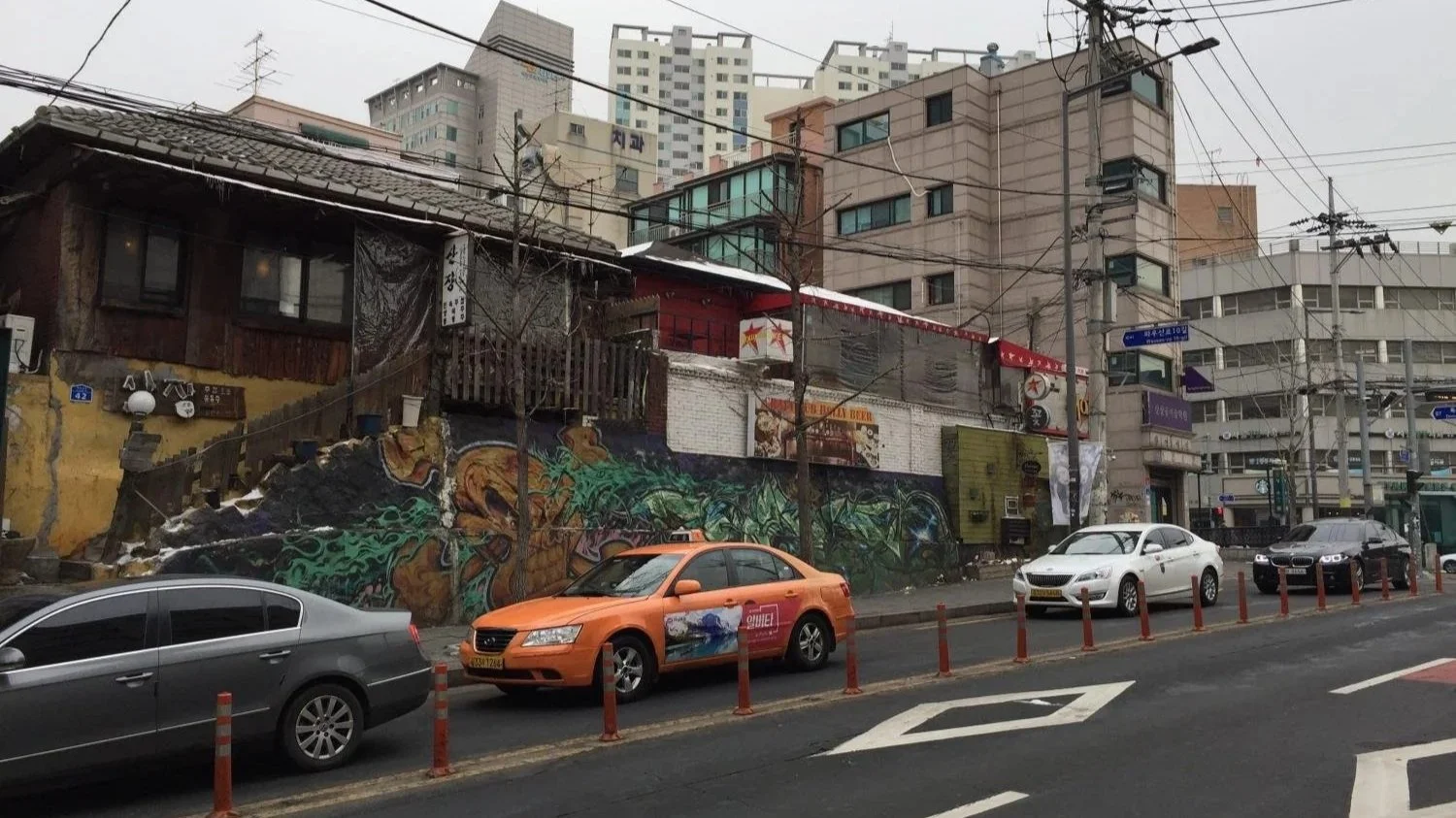 Cars line the streets of Seoul below electric wires.
