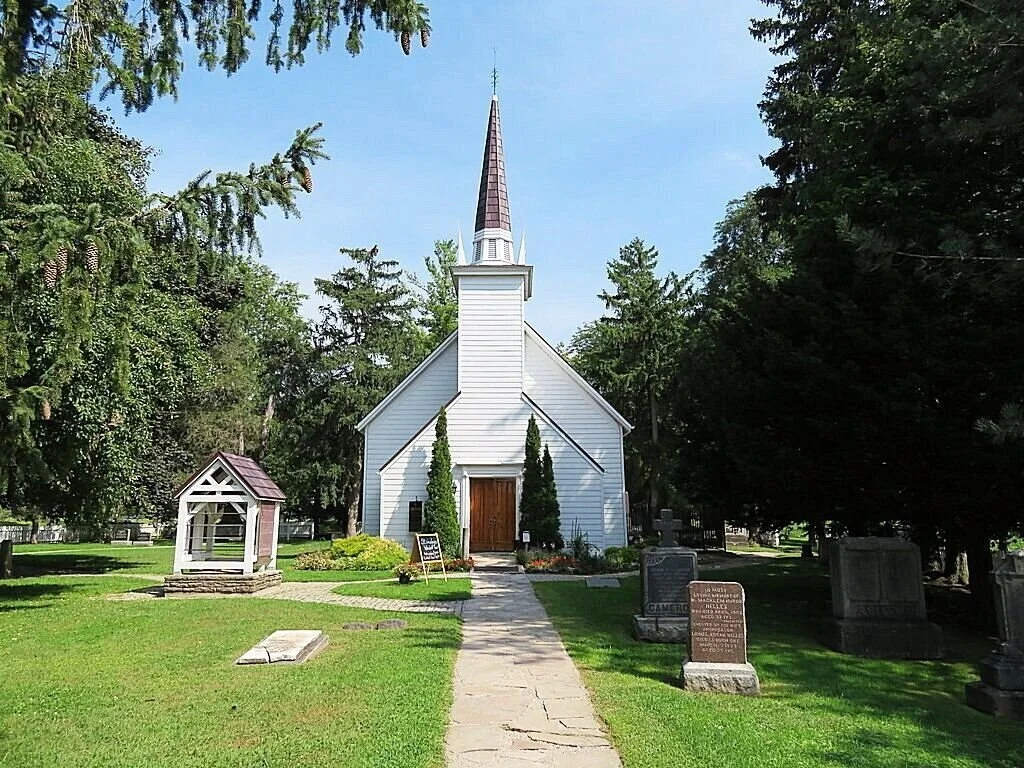 the Chapel of the Mohawks surrounded by green trees and grass.