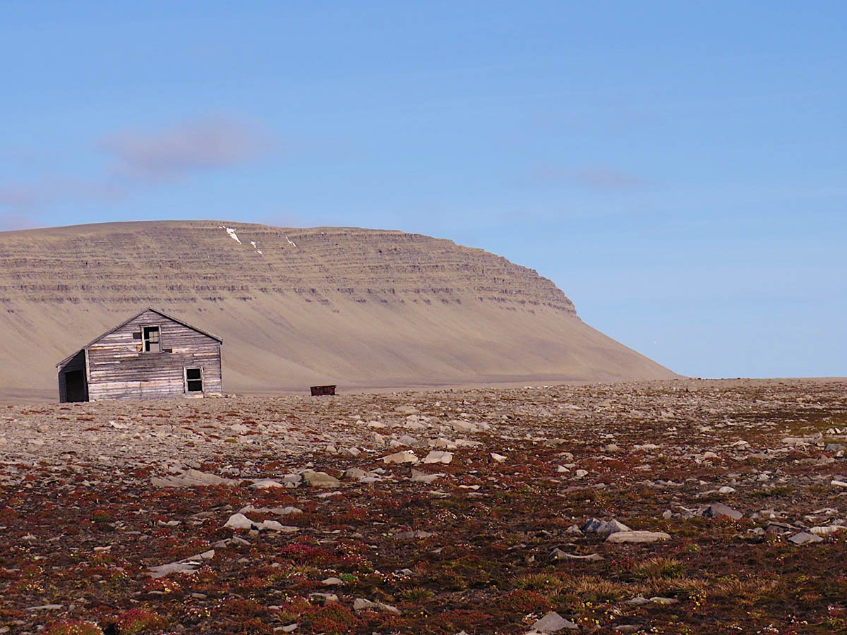 An abandoned HBC trading post on rocks behind mountains in Port Leopold.