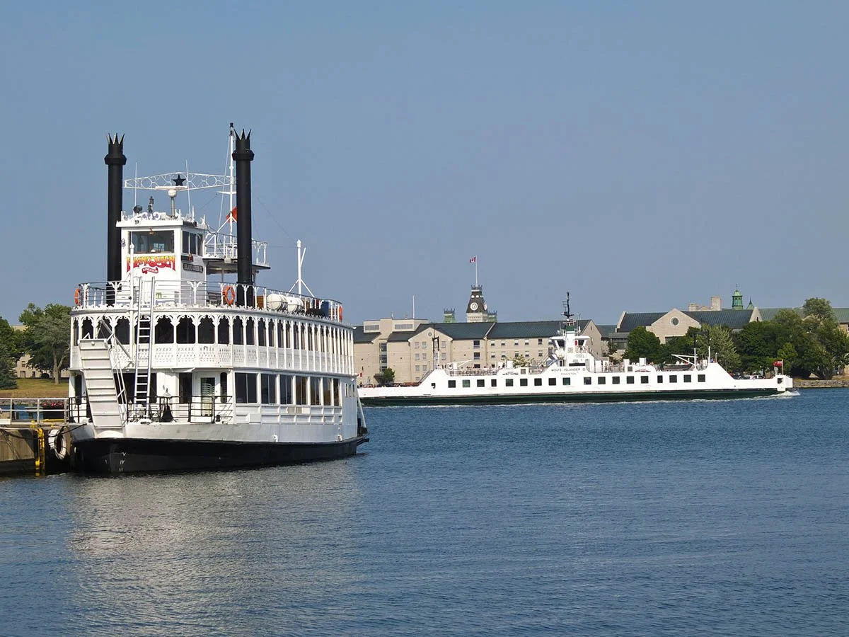 Boats pass along the water in Kingston during a sunny day.