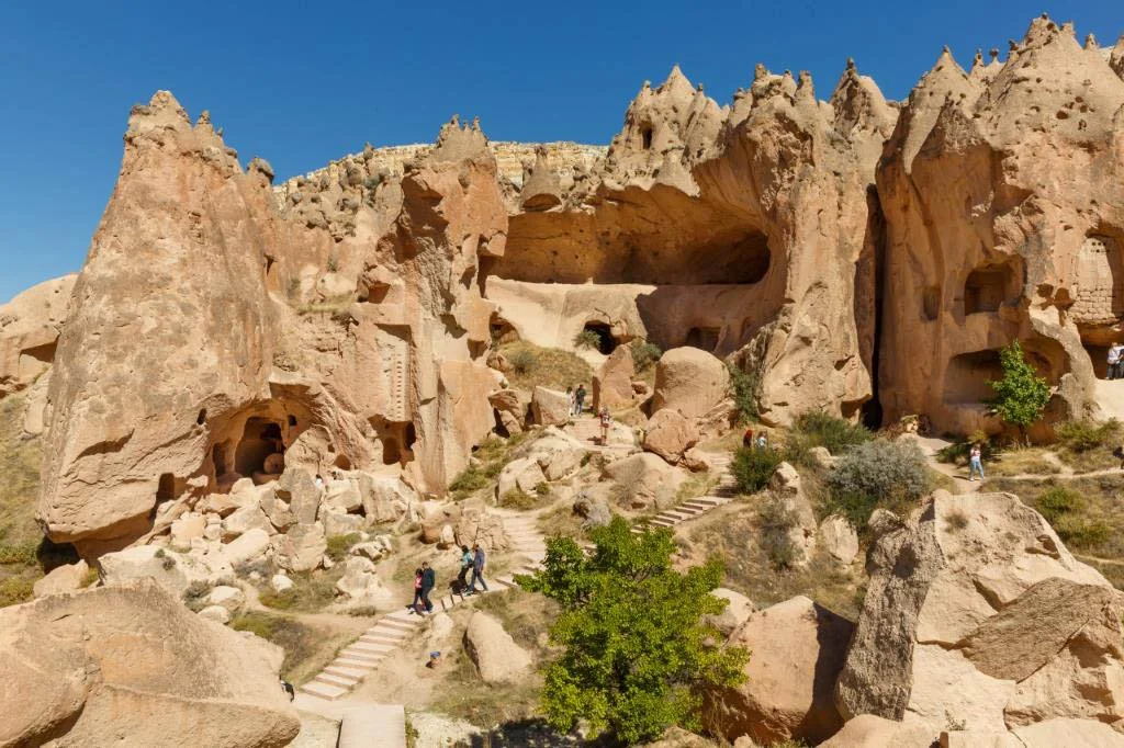 Tourists explore the jagged, limestone caves in Cappadocia.