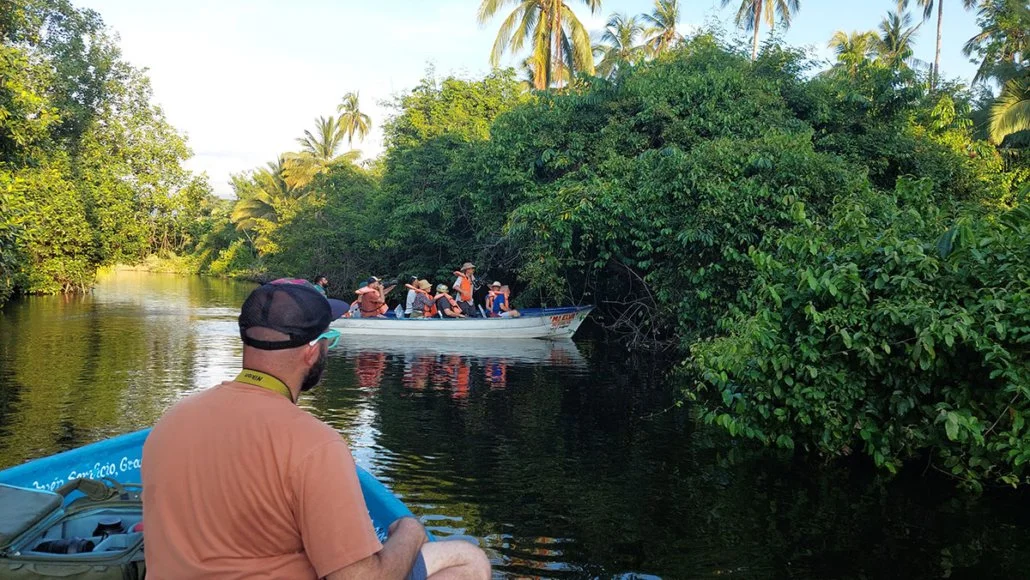 A group of tourists in orange lifejackets explore the San Blas ecosystem with La Rovara Estuary and Mangrove Swamps Tour.