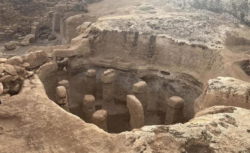 The ancient ruins of Göbekli Tepe peak out from the ground.