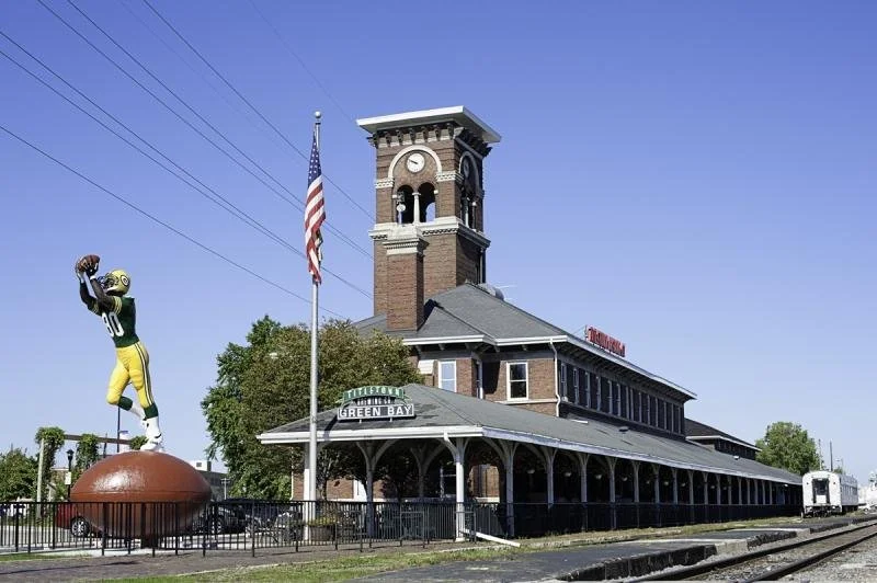 The Titletown Brewery's bell tower stands tall above the columns of the old train depot below.