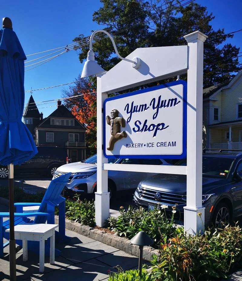 Blue and white logos, signs and chairs on the main street of Wolfeboro.
