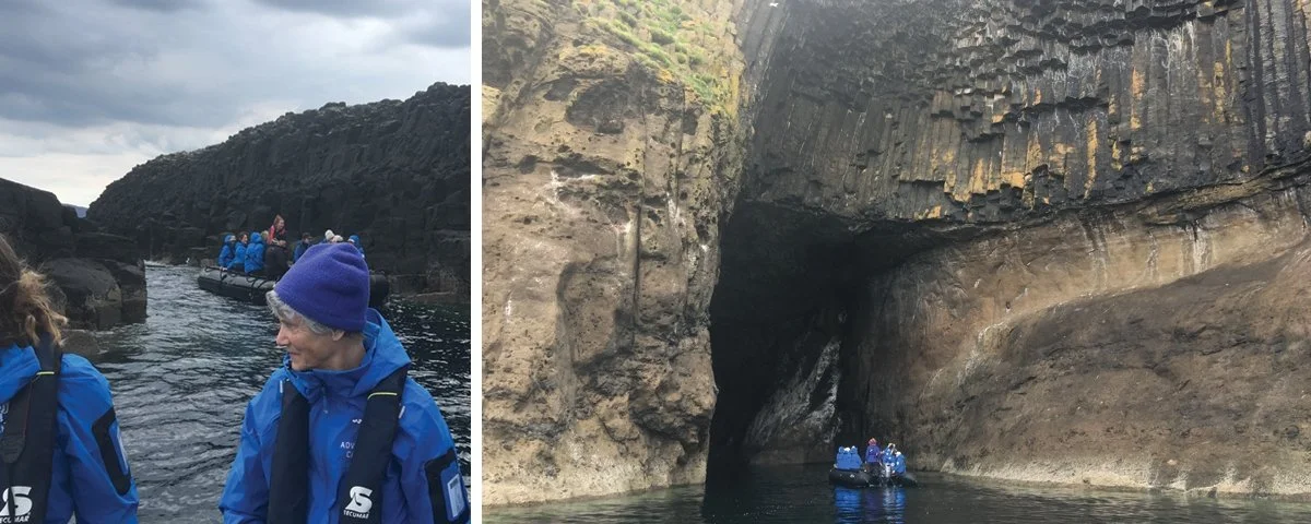 Blue-jacketed adventurers heading out by dingy to see the columnar basalt rock formations on the Island of Staffa.