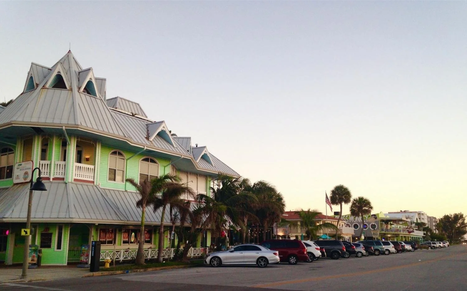 A green building and shops lining the street of Clearwater, Florida.
