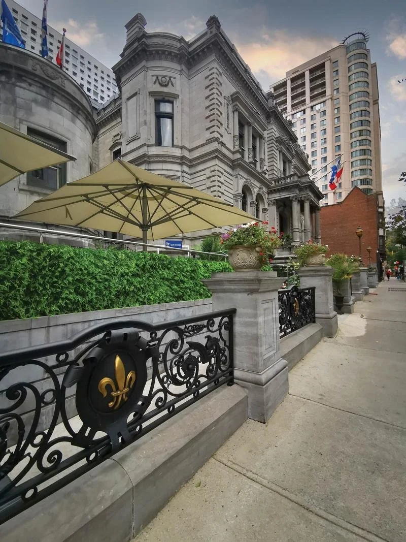An umbrella in front of a stone building.